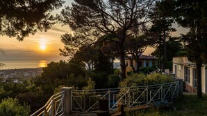 A wooden bridge with metal railings leading to a building with a tiled roof, surrounded by trees and overlooking a body of water. - Casina di Savolano Comfortable Holiday Residence (Livorno)