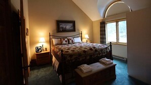 A bedroom with a bed, bedside lamps, a window, and a picture on the wall. - Relax at This Mountain View Condo in the Estates! (Campton)