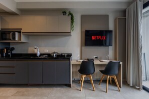 Basic Apartment | Private kitchen | Full-sized fridge, microwave, cookware/dishes/utensils, freezer - Studios Vila Madalena | Delfhy (São Paulo)