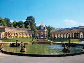 A classical building with a central dome and symmetrical wings, surrounded by a formal garden and a central water feature with statues. - Charming Apartment in Himmelkron (Himmelkron)