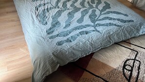 A bedroom with a bed, a wooden wall, a sink, and a string of lights. - Cabane au Bord de L'eau (Saint-Pierre-Eynac)