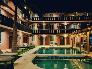 Un hôtel doté d’une piscine, de plusieurs balcons et d’espaces extérieurs aménagés pour se détendre.