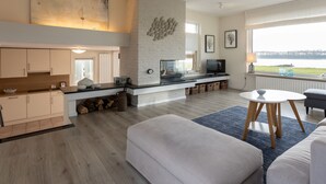 A modern living space with a kitchen, dining area, and seating area. - Holiday Home by Lake Veerse Meer (Kamperland)