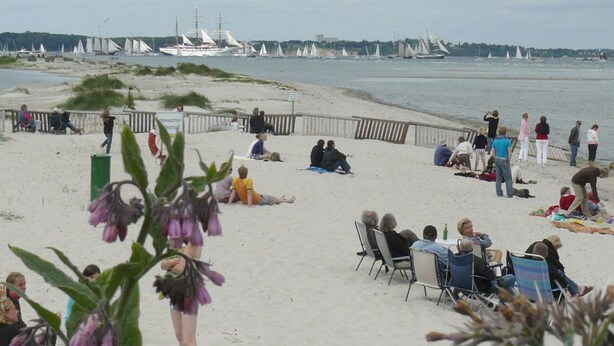 A beach with people relaxing and a row of sailboats in the background. - Nice Apartment Near Seabeach (Stein)