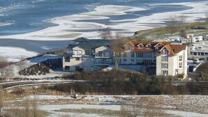 A residential area with houses near a frozen lake, featuring a bridge and sparse vegetation. - Nice Apartment Near Seabeach (Stein)
