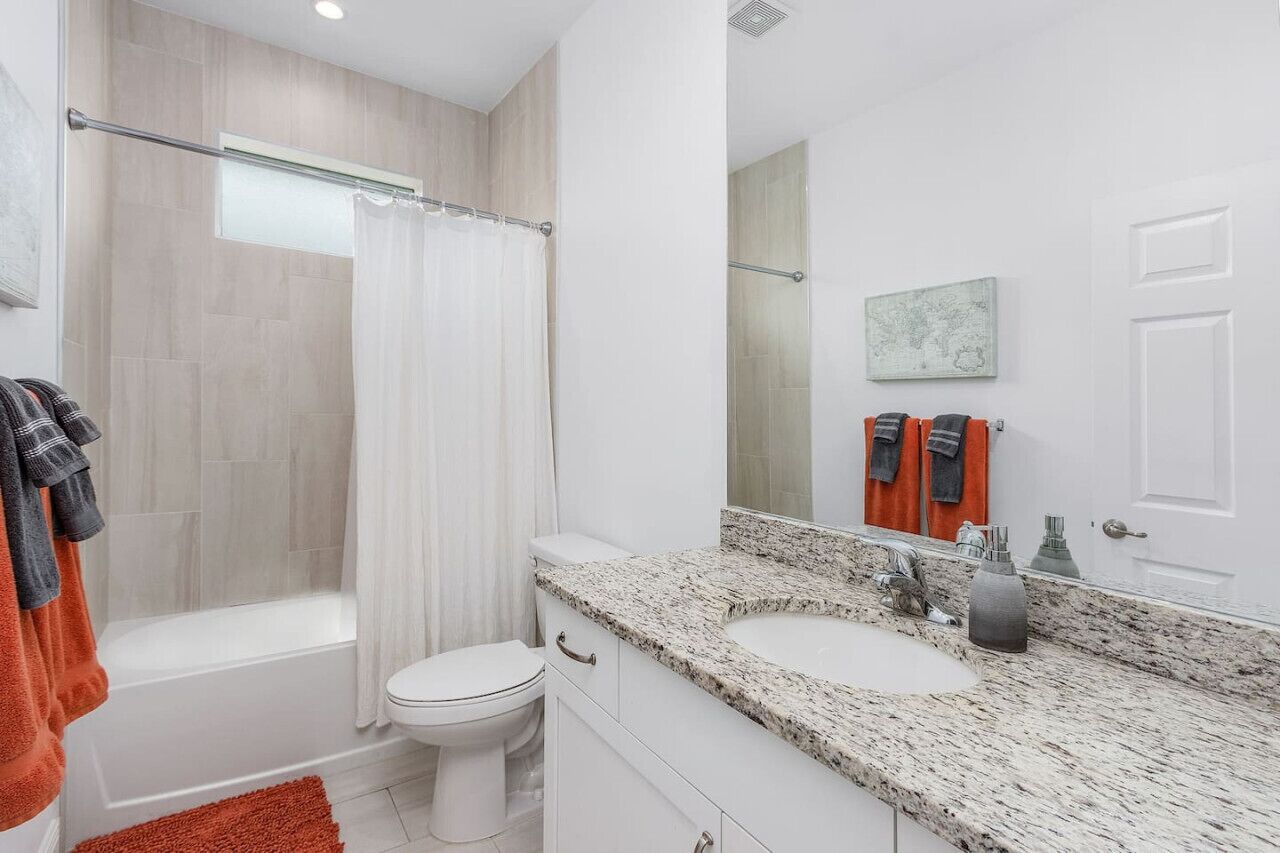 A modern bathroom with a shower, toilet, and dual sinks.