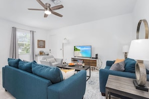 A modern living room with a sofa, a coffee table, and a television.