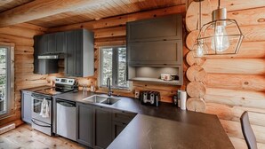 Een moderne keuken met houten wanden, roestvrijstalen apparatuur en een centraal eiland.