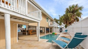 A two-story building with a swimming pool, outdoor seating, and palm trees. - Beach, pool time & fun times @ Blue Fish Lagoon (Fort Myers Beach)
