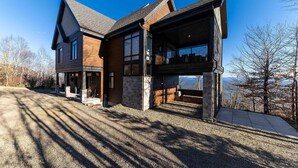 Ein zweigeschossiges Haus mit einer großen Garage und einer überdachten Veranda.