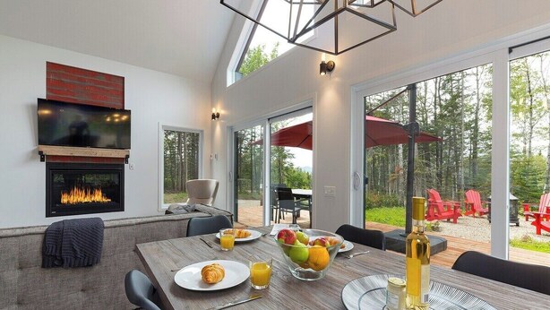 Un comedor moderno con chimenea, asientos al aire libre y vistas panorámicas.
