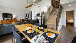 A modern kitchen with white cabinets, a microwave, and a stainless steel refrigerator. - Nordik 126: Private Hot Tub, Covered Terrace & BBQ (Les Éboulements)