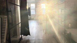 A room with a piano, a bed, and a window with sunlight streaming through. - 3-bedroom condo in Central Park, Manhattan, Times Square!
 (New York)