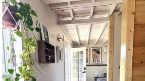 A wooden interior with a hallway leading to a room with a door. - Lillian’s blackberry cabin (Ava)