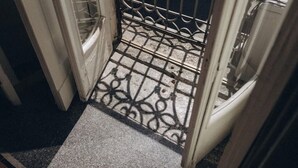 Kapea sisäänkäynti, jossa on metallinen portti ja laatoitettu lattia.