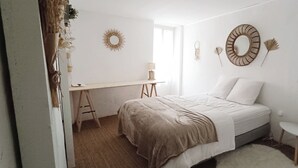 Un dormitorio con cama, escritorio y silla.