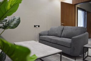 Deluxe Apartment, 1 King Bed, Kitchenette | Living area | 55-inch Smart TV with digital channels