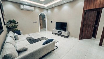 Deluxe Apartment, 2 Bedrooms, Kitchenette | Living area | 55-inch Smart TV with digital channels