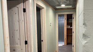 A hallway with wooden doors, a metal ceiling, and a wooden floor.