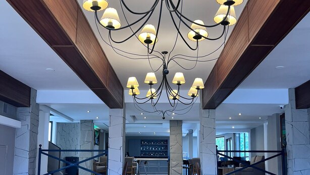 A spacious lobby with a modern chandelier, a staircase, and a seating area with a unique coffee table. - Cerro Calafate Hotel (El Calafate)