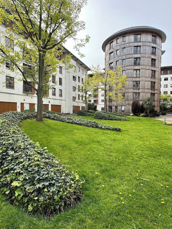 Stylish residential building with balconies and lush green surroundings.