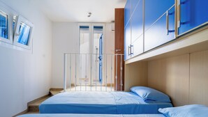 Una camera da letto con due letti, una testiera in legno e vista su un balcone.