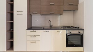Una cucina moderna con piano cottura a gas, forno e mobili a incasso.
