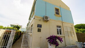 Un immeuble de deux étages sur lequel est apposée une enseigne indiquant qu’il s’agit des Blue Waters Condos.