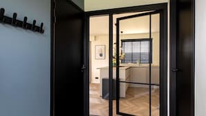 Una cocina moderna con suelo de espiga, una ventana con persianas y una encimera con fregadero.