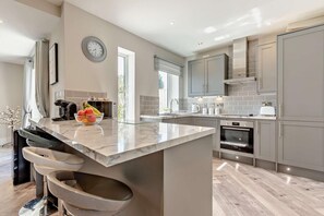 Een oven, een vaatwasser, een kinderstoel, kookgerei, borden en bestek