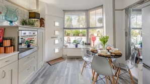 Una cocina moderna con comedor, ventanas amplias y vistas al exterior.