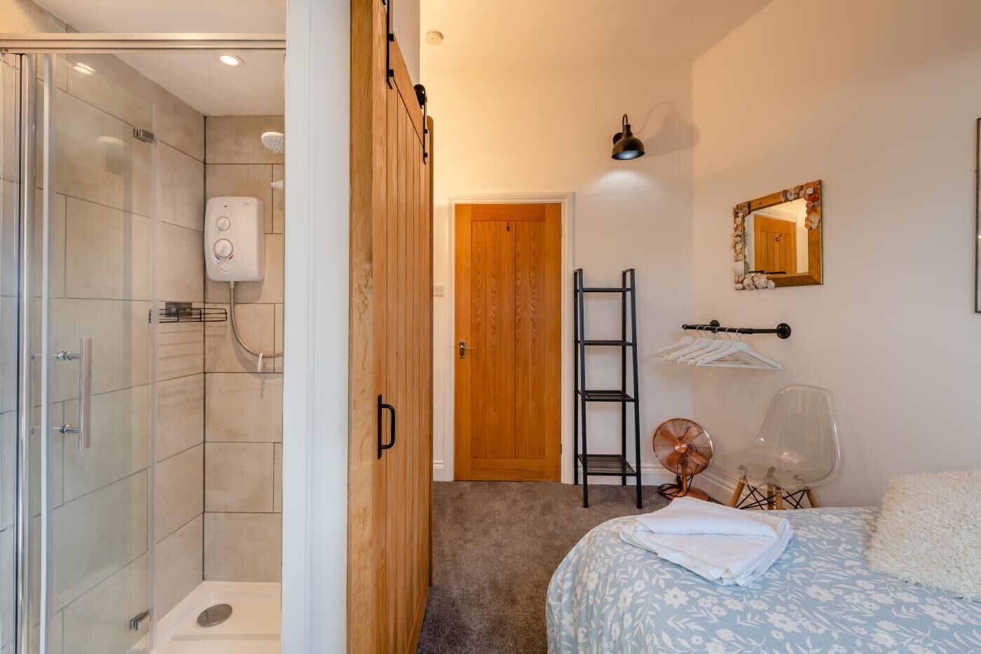 A modern bathroom with a glass shower enclosure, a toilet, and a white toilet paper holder.