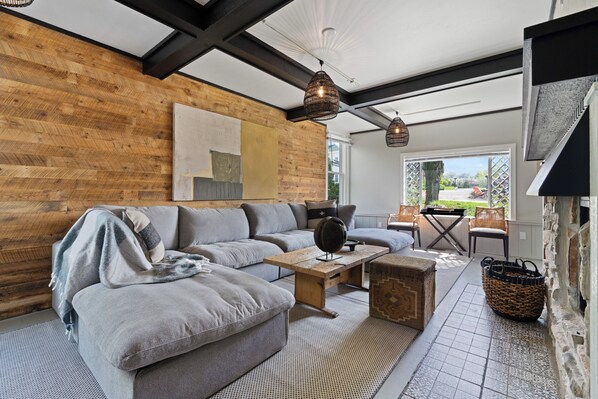 Ein modernes Wohnzimmer mit einem Ecksofa, einem Couchtisch und einem Kamin.