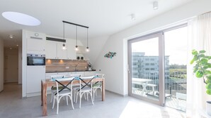 Een moderne keuken met een centraal eiland, witte kasten en hanglampen.
