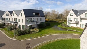 Een modern wooncomplex met meerdere tweelaags huizen, elk voorzien van balkons en grote ramen.