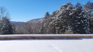 A snow-covered landscape with a stone wall and snow-covered trees. - Bluestone Manor--spacious mountain home for your next adventure (Nimitz)