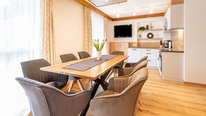 Eine moderne Küche mit Flachbildfernseher, Holzschränken und einer Kaffeemaschine.