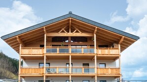 Ein mehrstöckiges Holzgebäude mit Balkonen und großen Fenstern.