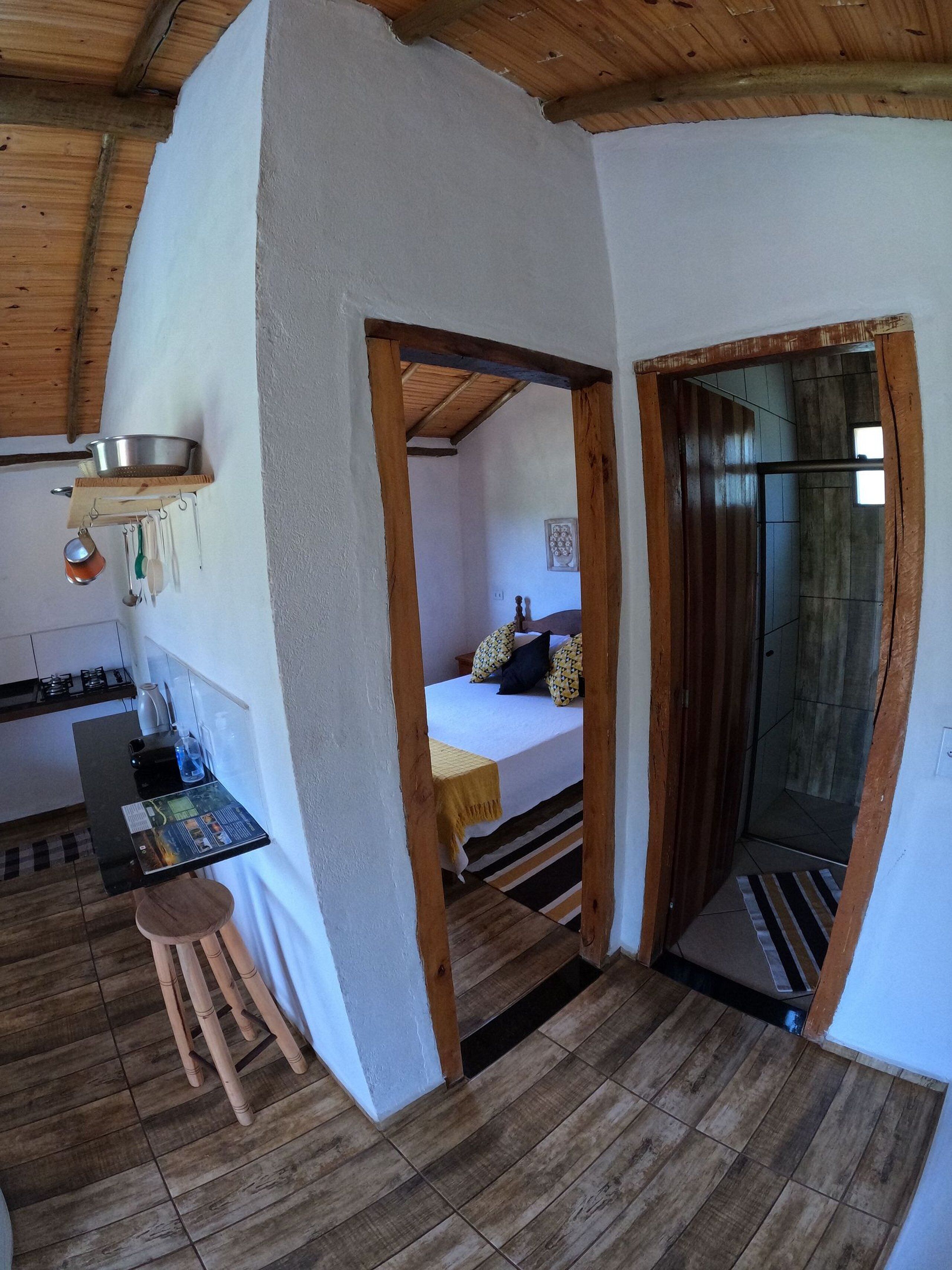 Habitación pequeña con kitchenette, cama y zona de ducha.