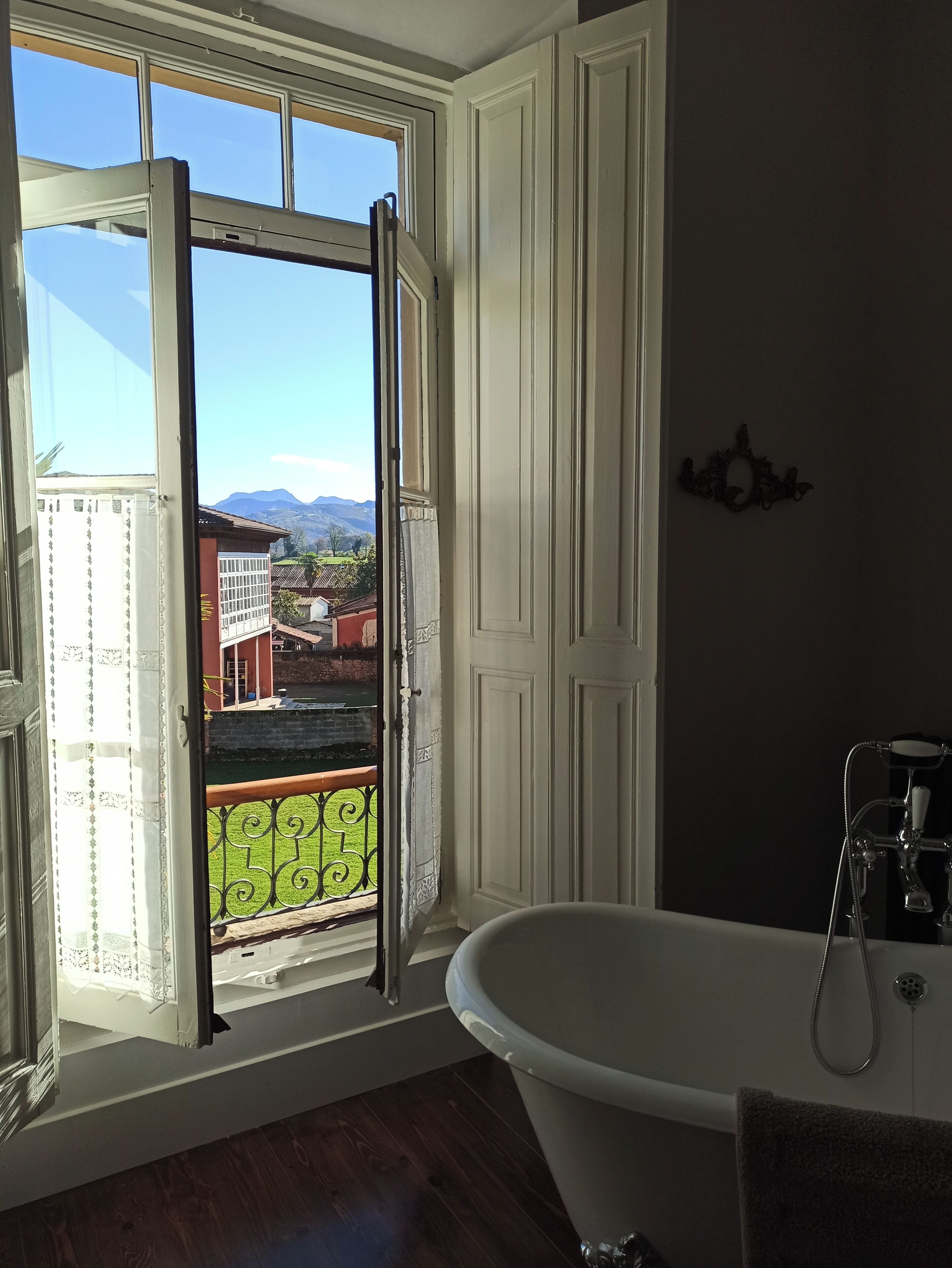 Un baño con bañera, una ventana que ofrece vistas a las montañas y una puerta.