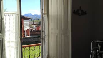 Ein Badezimmer mit Badewanne, einem Fenster mit Bergblick und einer Tür.
