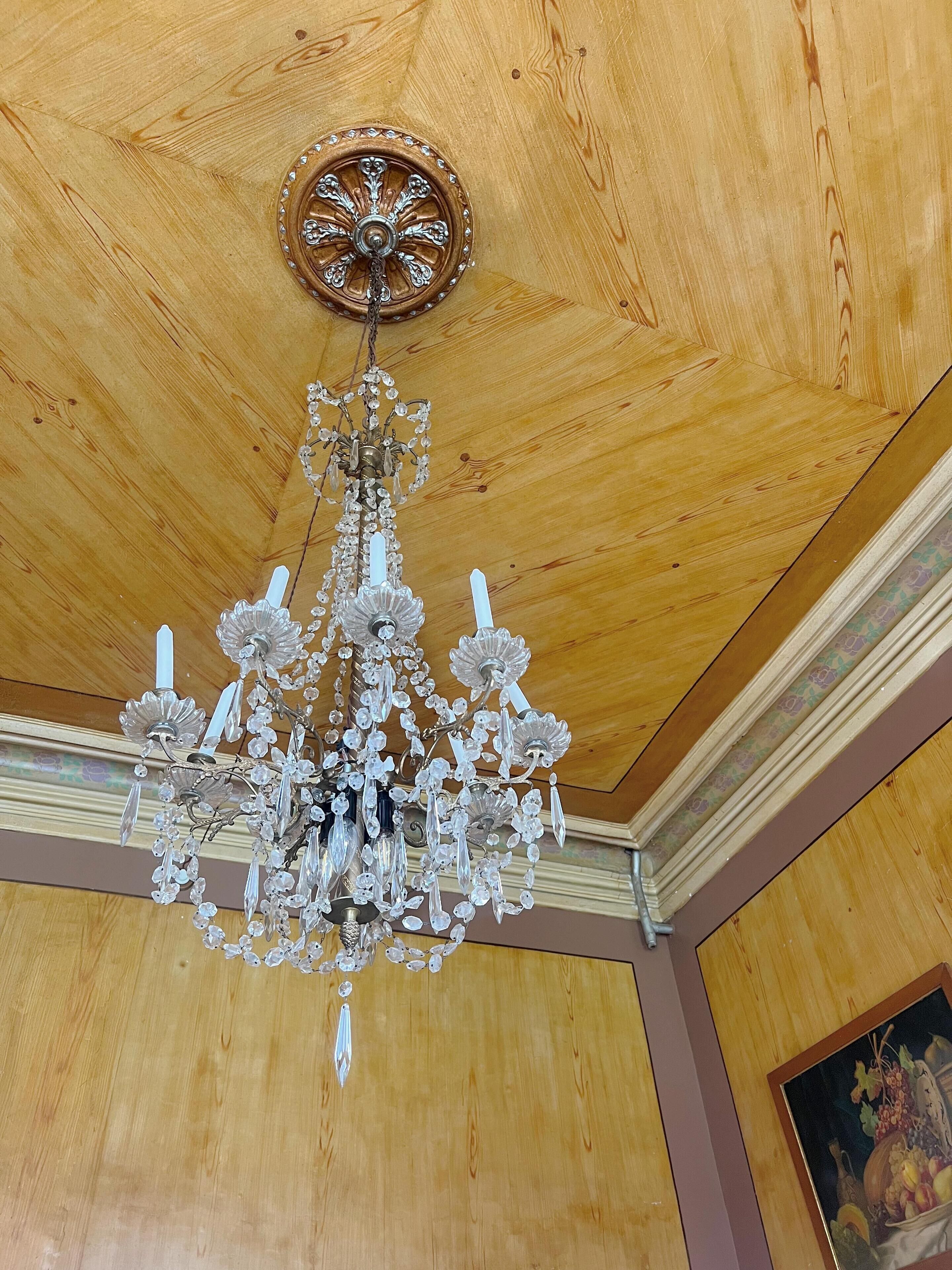 Un candelabro con adornos de cristal colgando del techo de madera.