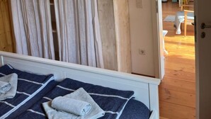 Quarto com uma cama, guarda-roupa de madeira e cortina.