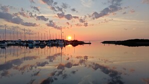 Satama, jossa veneet on ankkuroitu auringonlaskun aikaan.