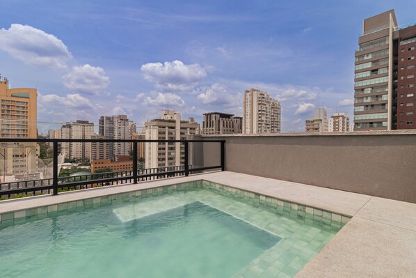 Ein Pool auf dem Dach mit Blick auf die Stadt.