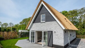 A modern house with a sloped roof and a brick facade.