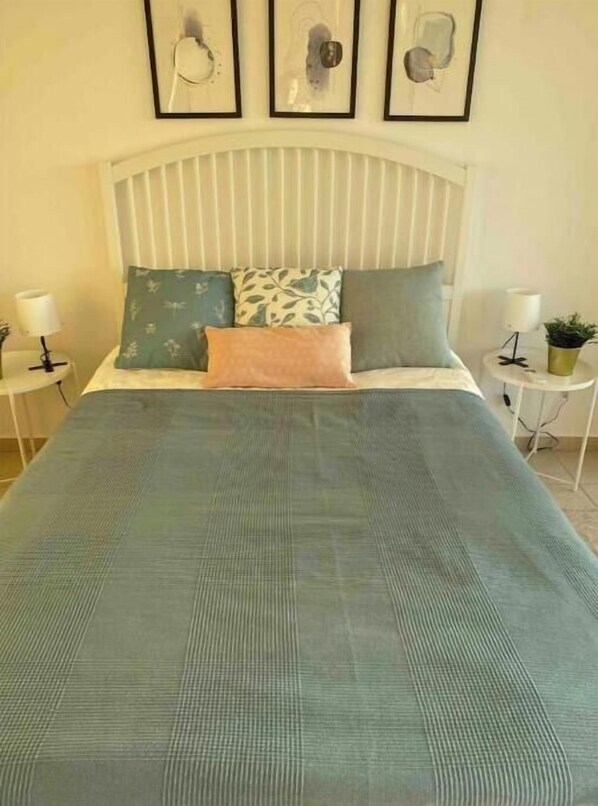 Cozy retreat with a large bed, two nightstands, and framed artworks.
