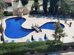Relax by the resort's curved pool surrounded by lush landscaping and comfortable lounge chairs.