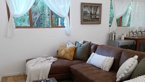 A living room with a brown sofa, a coffee table, and a striped rug.