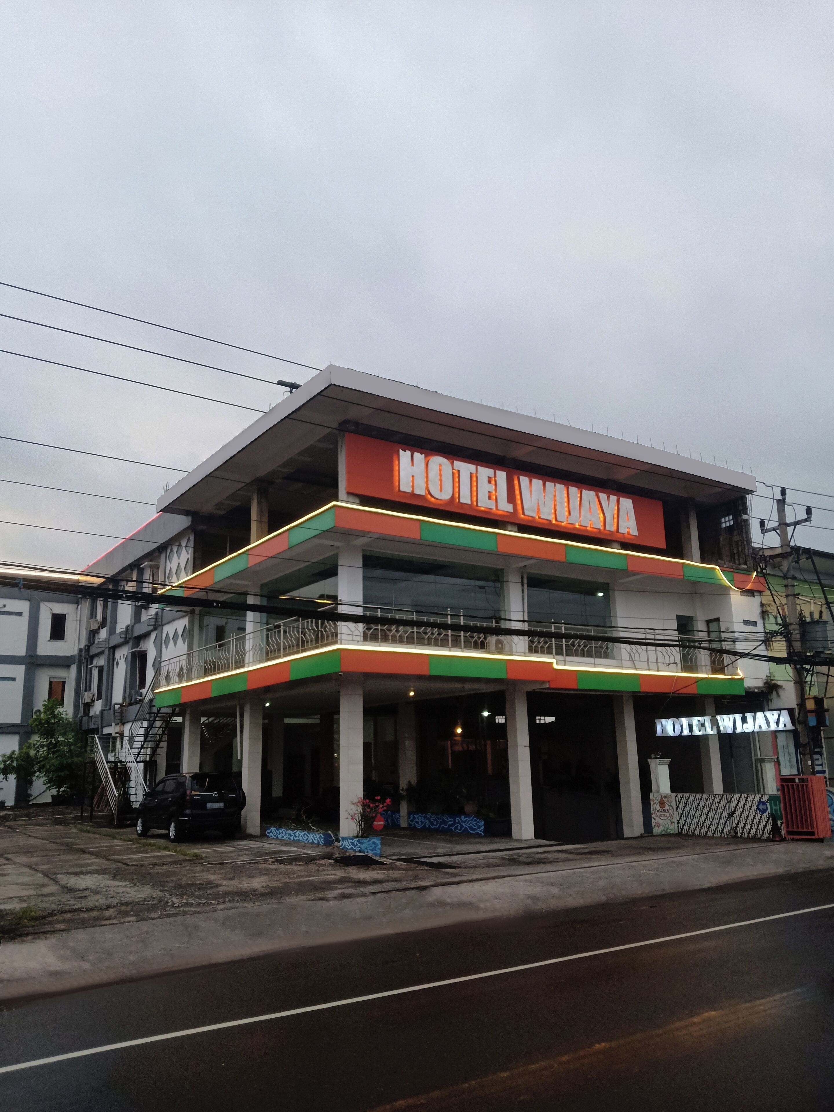 Un hôtel dont l’enseigne, bien visible, porte l’inscription « HÔTEL WIJAYA ».